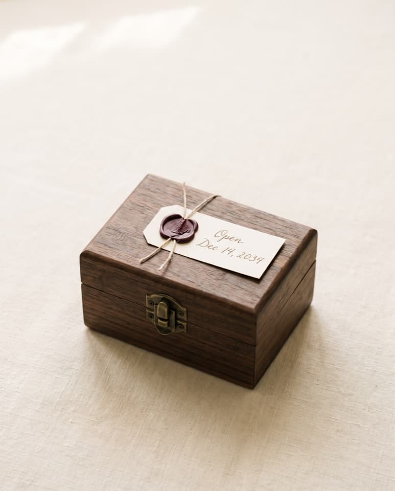 The same box closed, with a wax-sealed tag reading Open Dec 14, 2034